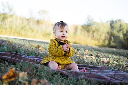 Baby Wearing Yellow Crochet Long Sleeve Dress Sitting on Brown Textile thumbnail