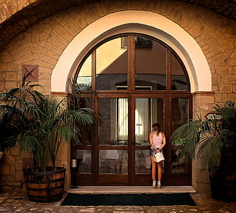 woman standing in front of brown wooden window pane thumbnail