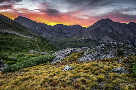 mountains under cloudy sky during orange sunset thumbnail