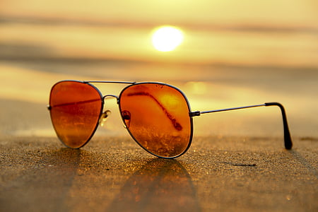 orange aviator sunglasses with silver frames on brown sand thumbnail