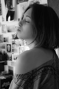 greyscale photo of woman wearing off-shoulder top closing her eyes inside room thumbnail