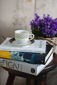 Books and purple flowers on a wooden stool by the bed thumbnail