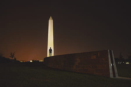 silhouette man standing beside tower thumbnail