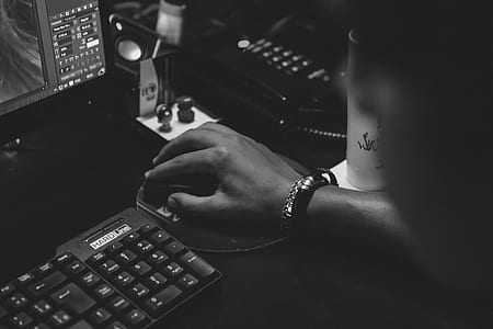grayscale photography of person holding computer mouse thumbnail