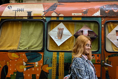 woman in blue and gray cardigan standing beside bus thumbnail