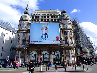 screen on white building during daytime thumbnail