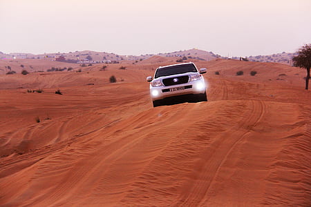 white vehicle on sand during daytime thumbnail