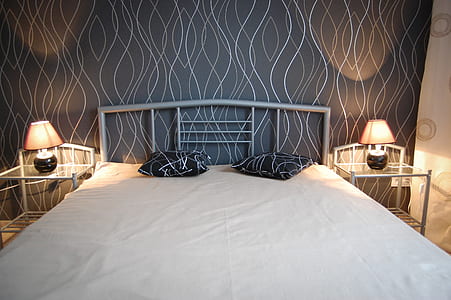 bed between two lighted table lamps thumbnail