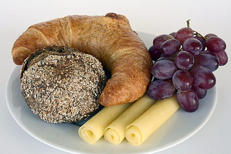 purple grapes beside croissant in plate thumbnail