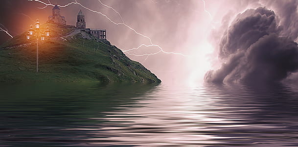 gray castle on top of mountain near body of water thumbnail
