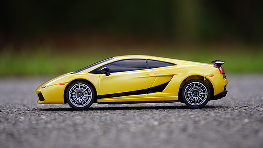 yellow Lamborghini Gallardo die-cast metal model on asphalt road during daytime thumbnail