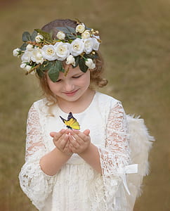 yellow and black butterfly perching on girl wearing angel costume hands thumbnail