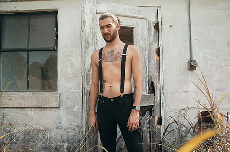 man wearing black pants standing in front of door thumbnail