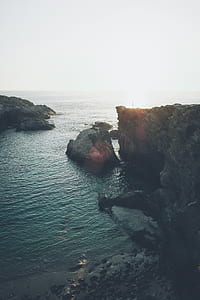 aerial photography of mountain on body of water thumbnail