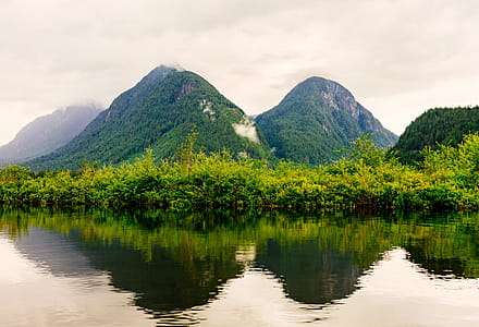 Landscape Shot Of Green Mountains Below Foggy Sky Photo thumbnail