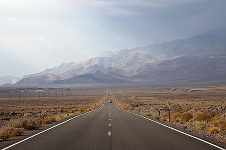 gray asphalt road with mountains during daytime thumbnail