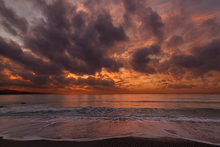 shore under orange and gray sky at dusk thumbnail