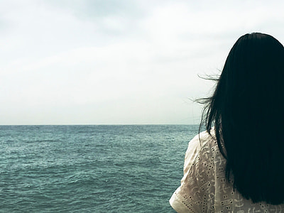 black haired woman near body of water during day time thumbnail