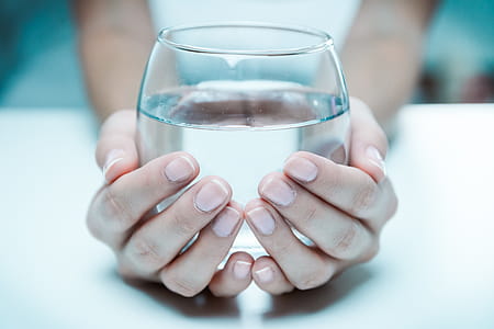Female hand holding a glass of clean water, close-up. thumbnail