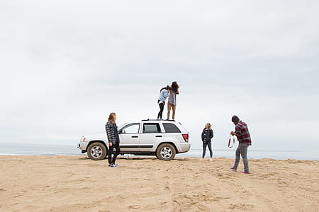 two woman standing on SUV roof thumbnail