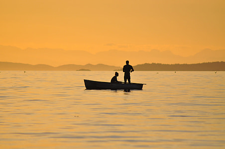 silhouette of two person riding on canoe on body of water during golden hour thumbnail