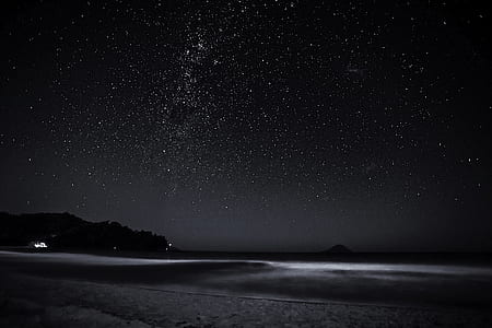 grayscale photo of body of water under stargazing phenomenon thumbnail
