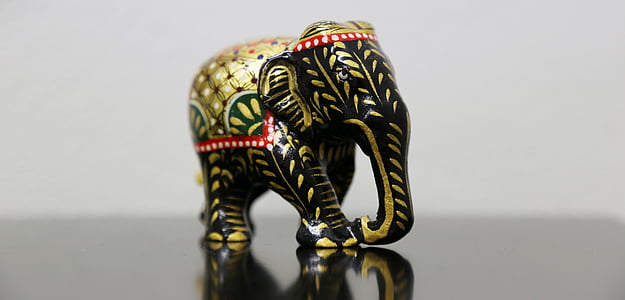 black and gold elephant figurine on black surface thumbnail