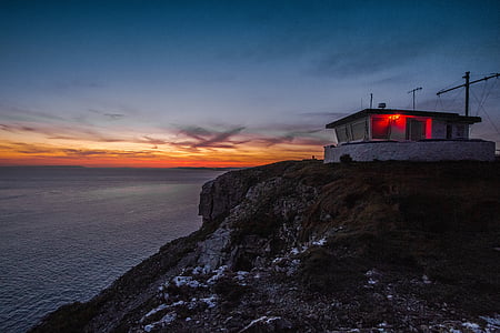 white concrete house near cliff during golden hour thumbnail