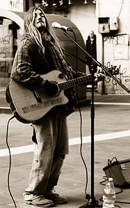 sepia photography of man playing guitar thumbnail