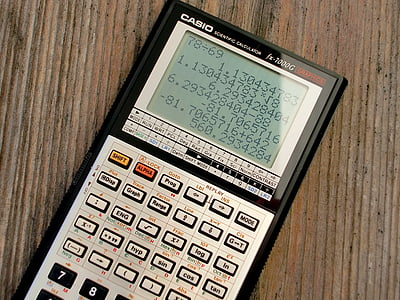 black and gray Casio graphing calculator on brown surface thumbnail