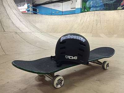 black skateboard on ramp with black Tan booster helmet thumbnail