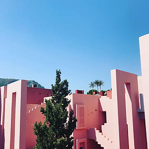 white concrete house and green tree under blue sky thumbnail