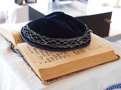 blue and white hat on brown opened Quran thumbnail