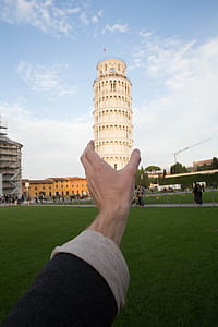 Perspective photograph of hand holding Leaning tower of Pisa, Italy thumbnail