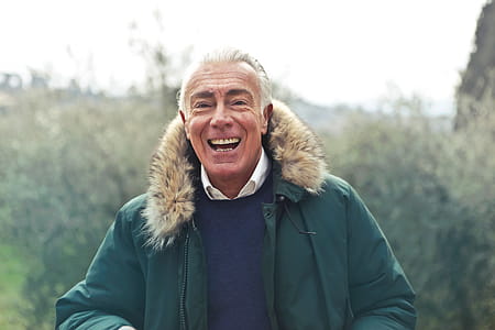 Middle Aged Man Laughing And Posing In Green Faux Fur Hooded Jacket thumbnail