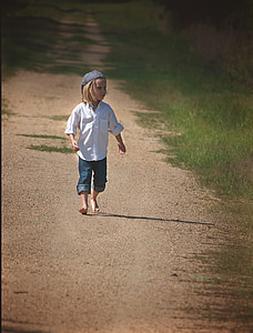 boy wearing white dress shirt and blue denim pants walking on sand during daytime thumbnail
