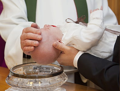 father pouring holy water on baby's head thumbnail