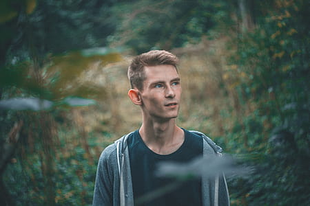 Man in Black Crew-neck Shirt Standing Near Green Leaf Plants thumbnail