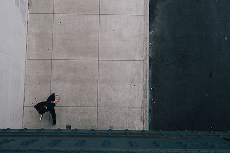 person wearing black t-shirt walking on pathway thumbnail