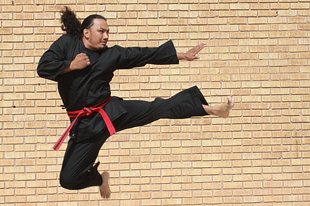 man in black karati gee doing flying kick thumbnail