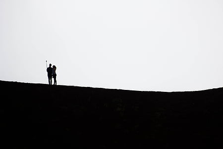 silhouette of woman and man holding monopod thumbnail