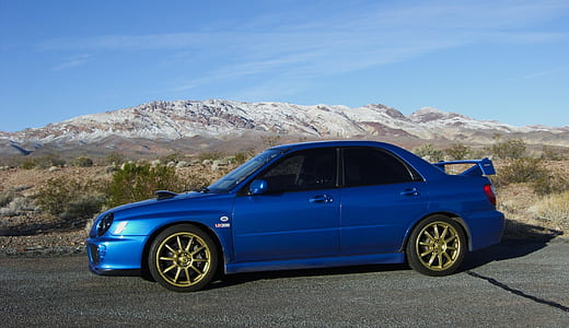 blue Subaru Impreza sedan on road near mountain thumbnail