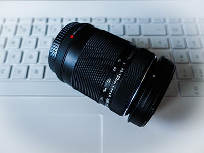 top-view photography of black DSLR lens on white computer keyboard thumbnail
