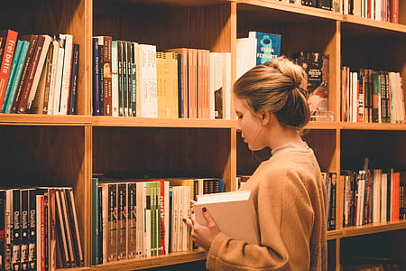 woman standing beside book shelf thumbnail
