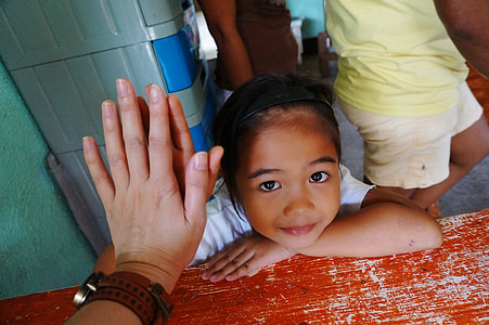 smiling girl leaning beside red wooden table thumbnail