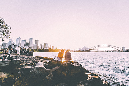 people on shoreline near Sydney opera house and Sydney Harbor bridge during sunset thumbnail