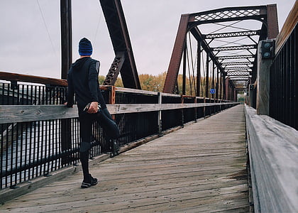 man wearing black tracksuit and blue knit cap on bridge thumbnail