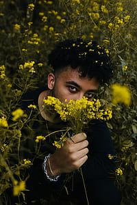man holding yellow petaled flowers thumbnail