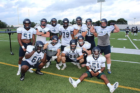 Football Player Huddled Together in Field thumbnail