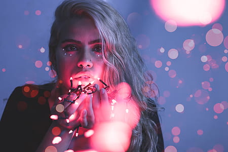 focus photography of woman holding string lights thumbnail